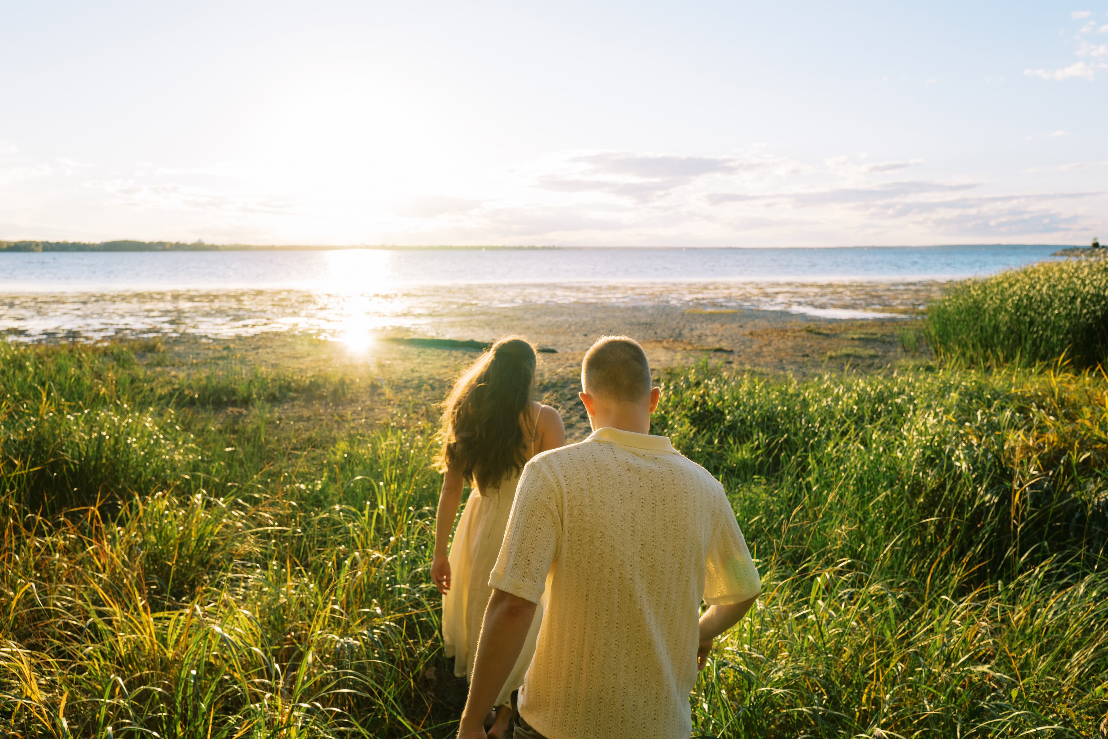 Keira and Paul walking toward the water at sunset